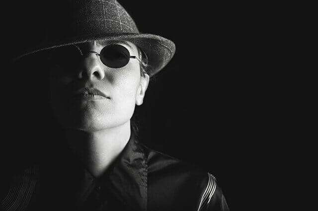 private-investigator-UK-wearing-black-hat-with black-glasses