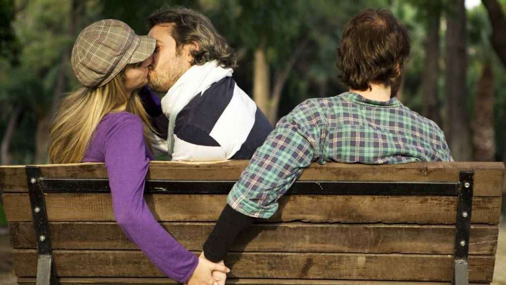 couple-kissing-each-other-while-holding-hand